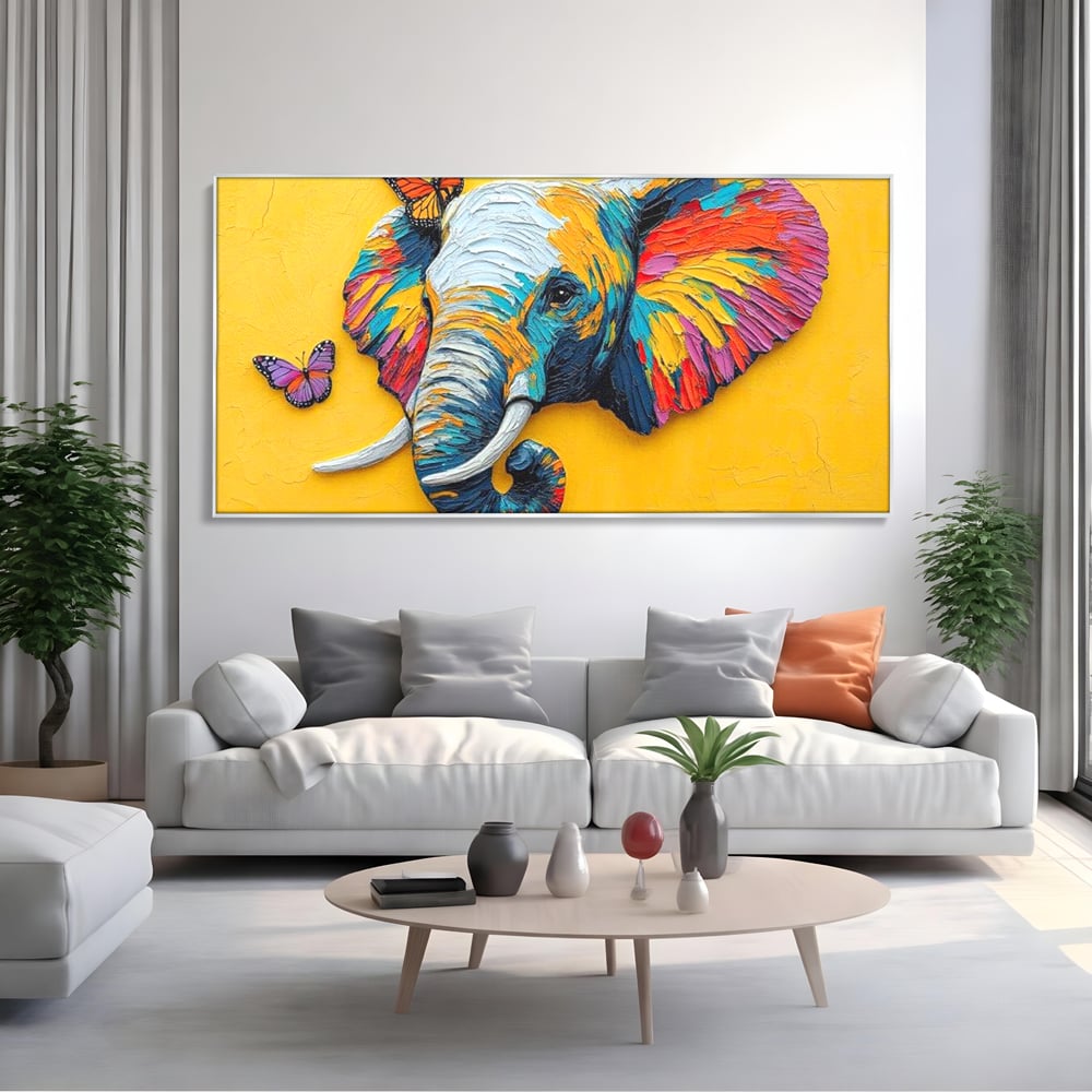 Tablou canvas cu tablou canvas cu elefant colorat si fluturi, in rama de aluminiu argintiu, pe perete intr-un living